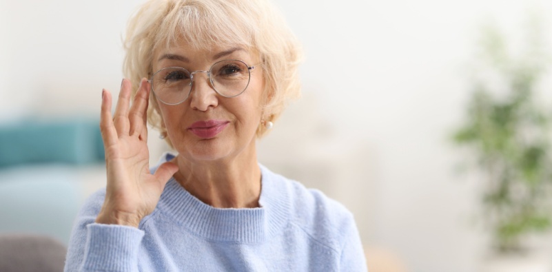 Portrait of a grandmother touching the side of her glasses, smiling