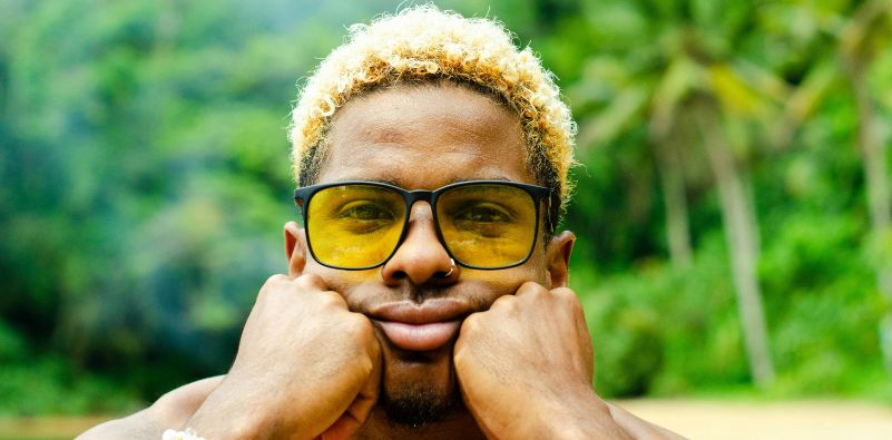 A man wearing yellow tinted sunglasses outdoors