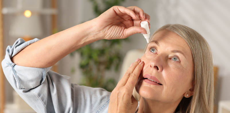 Woman applying lubricating eye drops to help relieve dry eye symptoms.