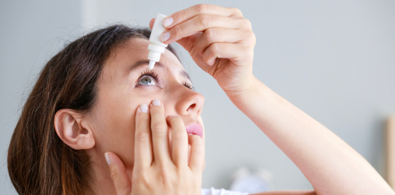 Woman applying eye drops