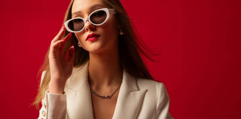 Stylish young woman in a white suit wearing white cat-eye sunglasses