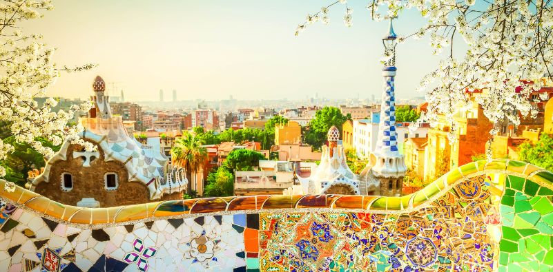 Panoramic view of Barcelona from Parc Güell, featuring Gaudi’s colourful mosaic tiles.